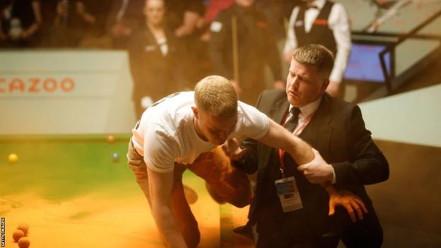 A protestor halts play at the World Snooker Championships