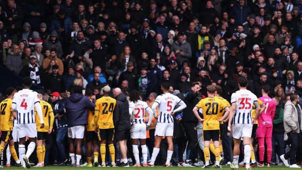 Wolves and West Brom players stand as fans clash