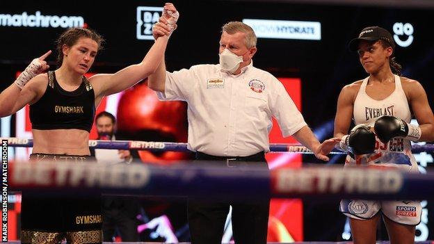 Katie Taylor's hand is raised as Natasha Jonas looks on