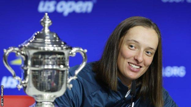 Iga Świątek looks at the US Open trophy after winning the 2022 women's singles title