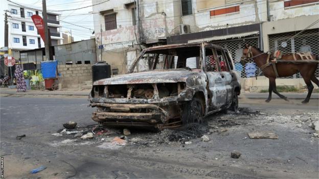 Charred remains of a car in Dakar after outbreak of violence