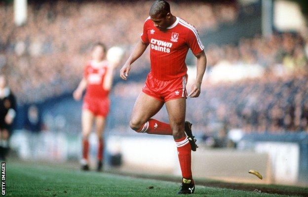 John Barnes de Liverpool talonne une banane qui a été jetée sur le terrain lors d'un match à Everton en 1988