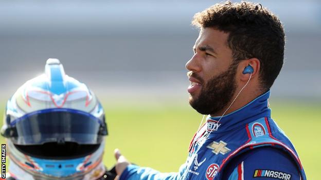 Bubba Wallace picks up his race helmet