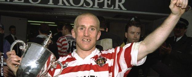 An old photo of Shaun Edwards in Wigan kit with a trophy