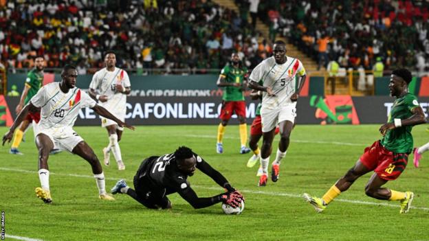 Guinea keeper Ibrahim Kone makes a save against Cameroon