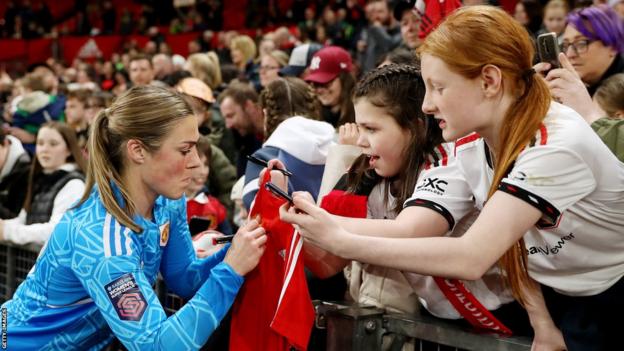 Mary Earps signs a fan's shirt at Old Trafford