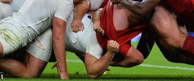 Kieran Brookes (left) goes to ground under pressure from France