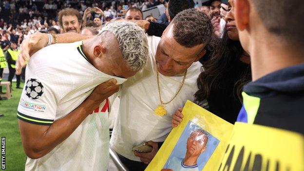 Richarlison celebrates with a friend after making his Champions League debut for Tottenham