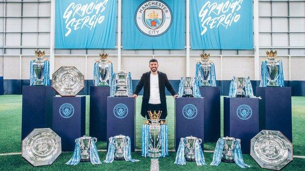 El delantero del Manchester City Sergio Agüero en la foto con los 15 trofeos que ha ganado con el City hasta ahora: cinco Premier Leagues, una FA Cup, seis League Cups y tres Community Shields