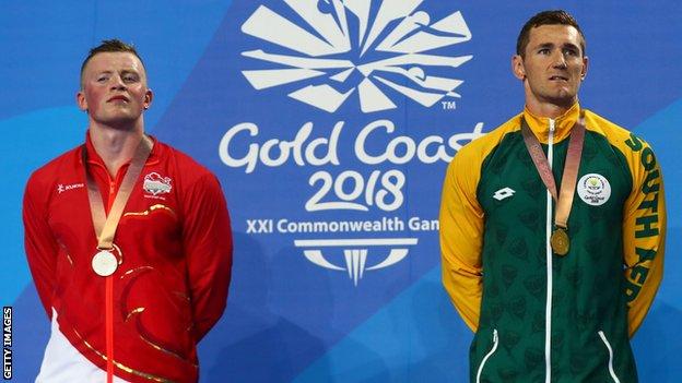 Adam Peaty on the podium next to Cameron van der Burgh after finishing second