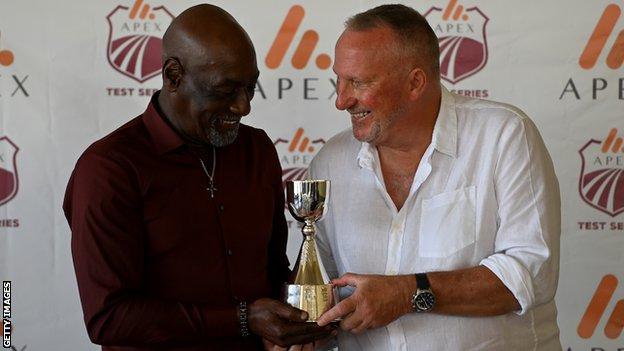 Sir Viv Richards (left) and Lord Botham (right) smile as they hold up the Richards-Botham trophy awarded to the winner of Test series between West Indies and England