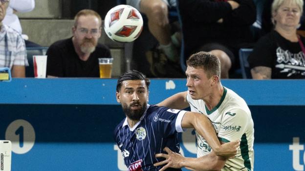 Luzern's Kemal Ademi (L) and Hibernian's Will Fish successful  enactment   during a UEFA Conference League Qualifier betwixt  FC Luzern and Hibernian astatine  the Swissporarena,