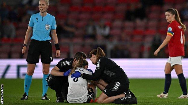 Simone Magill recibe atención médica tras sufrir una lesión en la rodilla contra Noruega