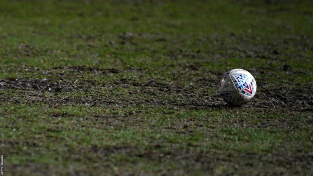 A ball on a muddy football pitch