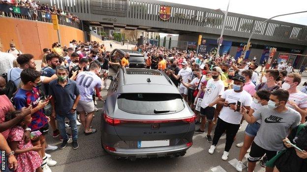 Fans gather outside the Nou Camp for Lionel Messi's press conference on August 8, 2021