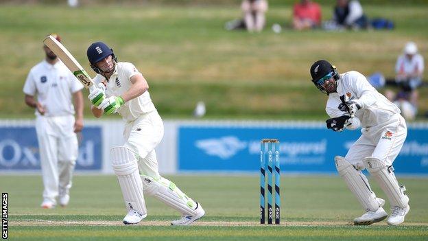 England batsman Jos Buttler plays a shot and New Zealand A wicketkeeper Tom Blundell turns to watch the ball in a warm-up match