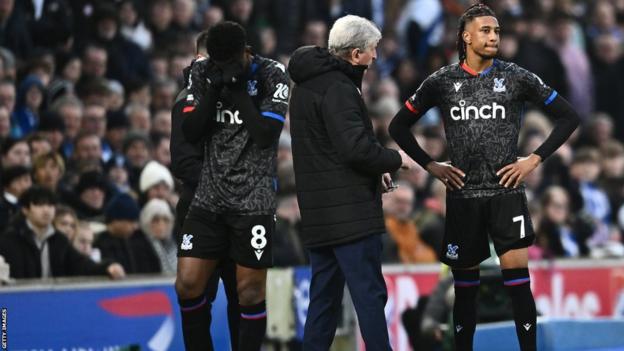 Roy Hodgson speaking to Michael Olise on the touchline after he suffered his injury