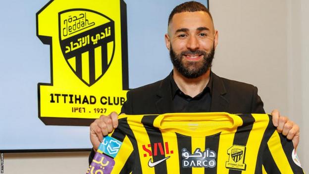 Karim Benzema holds up an Al-Ittihad shirt