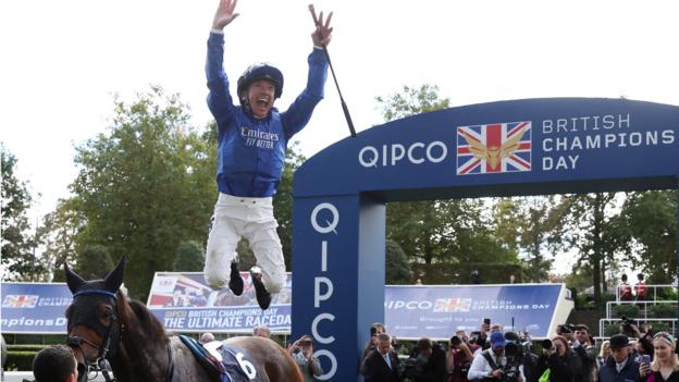 Frankie Dettori celebrates with a flying dismount after winning on Trawlerman