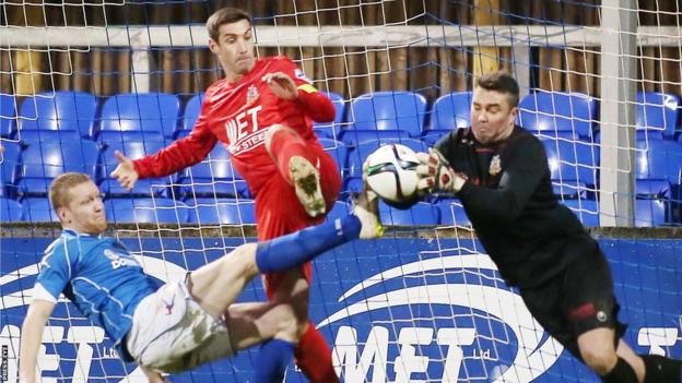 Portadown goalkeeper David Miskelly collects the ball as team-mate Keith O'Hara and Dungannon's David Armstrong look on