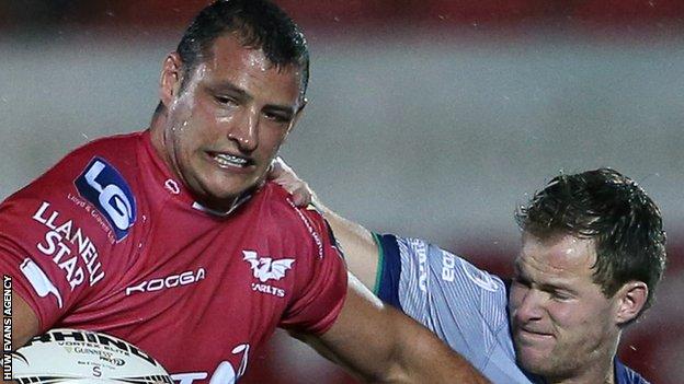 Aaron Shingler of Scarlets is tackled by Kieran Marmion