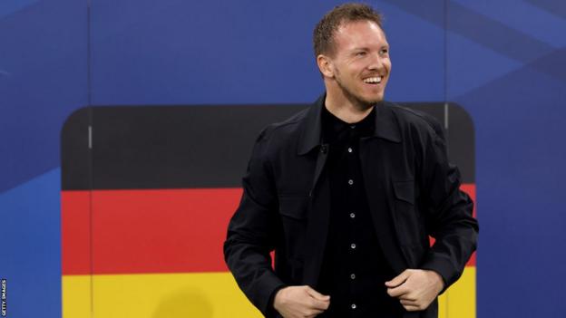Julian Nagelsmann stands in front of a Germany flag