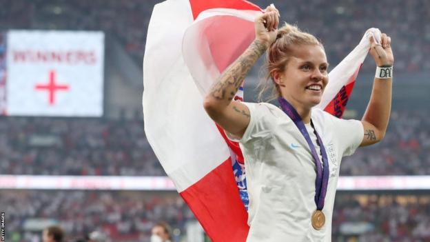 Rachel Daly of England celebrates with a flag and their winners medal