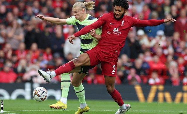 Liverpool defender Joe Gomez challenges Manchester City striker Erling Haaland