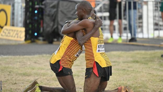 Uganda's Joshua Cheptegei (left) embraces countryman Jacob Kiplimo (right) after Kiplimo won the men's senior race of the 2023 World Cross Country Championships at Mount Panorama in Bathurst, Australia, on February 18, 2023