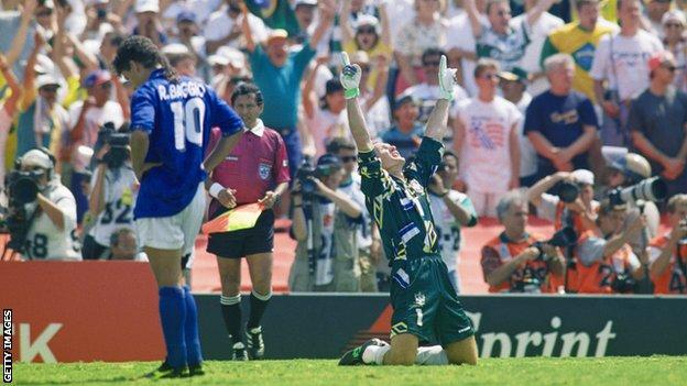 Taffarel celebrates winning World Cup 1994 as Roberto Baggio stands, dejected