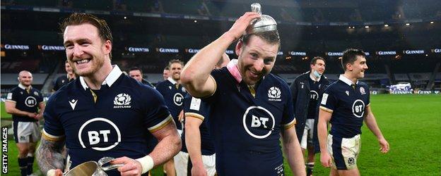 Scotland's Finn Russell holds the lid of the Calcutta Cup on his head as Stuart Hogg smiles