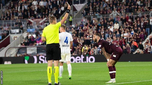 Referee Lawrence Visser shows a red card to Jorge Grant during a UEFA Europa League play-off second leg match between Heart of Midlothian and FC Zurich at Tynecastle,
