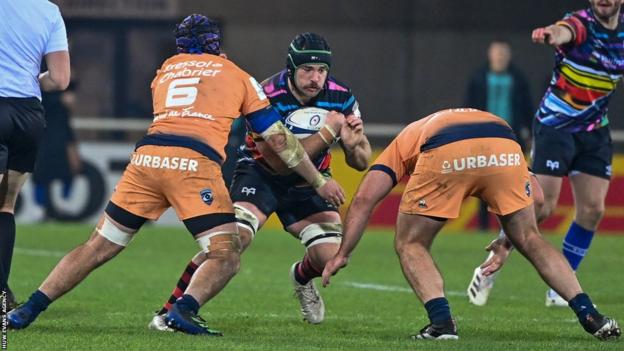 Morgan Morris of Ospreys is tackled by Clement Doumenc (L)