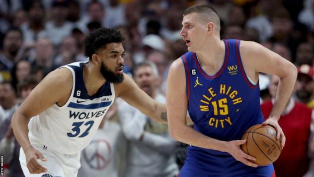 Nikola Jokic of the Denver Nuggets is guarded by Karl-Anthony Towns of the Minnesota Timberwolves