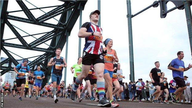 A runner wearing a Union Jack t-shirt crosses the Tyne Bridge