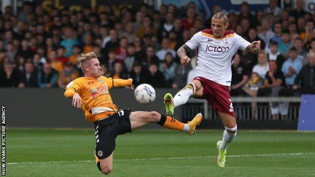 Ollie Cooper of Newport County looks to get a shot at goal as Oscar Threlkeld of Bradford City challenges