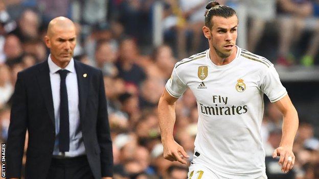 Zinedine Zidane (L) watches Real Madrid's Wales forward Gareth Bale