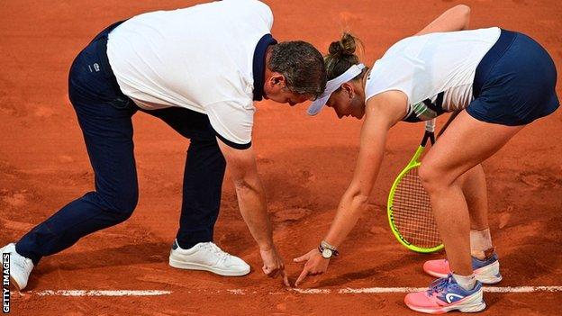 Barbora Krejcikova and umpire Pierre Bacchi check the line