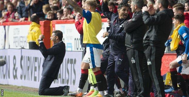 Pedro Caixinha falls to his knees to celebrate as Rangers score a third goal to stun Aberdeen at Pittodrie