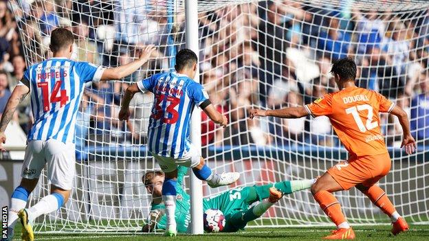 Dan Grimshaw saves the ball for Blackpool against Huddersfield
