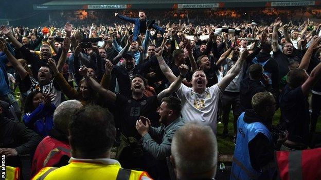 Port Vale fans celebrate on the pitch