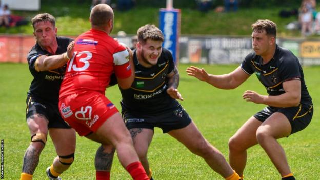 Cornwall players tackle an opponent from North Wales Crusaders