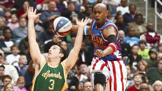 Harlem Globetrotter Shane 'Scooter' Christensen evades the reach of Washington General Caleb Kimbrough as he dribbles downcourt