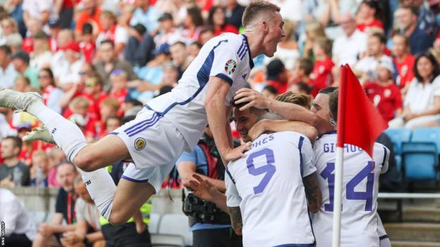 Scott McTominay dives on his Scotland team-mates in celebration