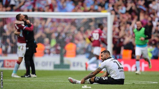 Bradley Johnson de Derby se sienta mientras Aston Villa celebra su victoria en los play-offs del campeonato 2018-19