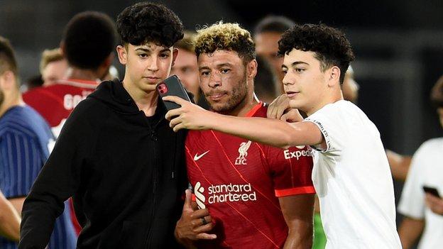 Fans taking selfies with Alex Oxlade-Chamberlain of Liverpool at the end of the pre-season match between Hertha BSC and Liverpool at Tivoli Stadion