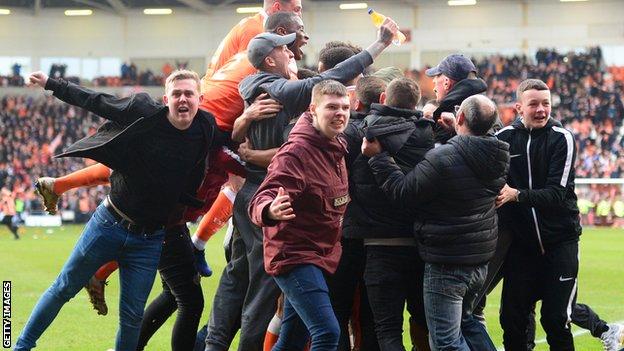 Blackpool fans celebrate on the pitch