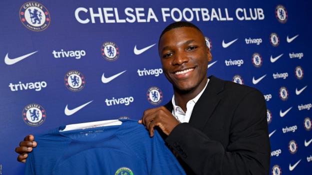 Moises Caicedo holds a Chelsea garment  aft  signing for the club