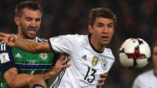 Northern Ireland defender Gareth McAuley challenges Thomas Muller of Germany