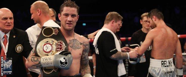 Ricky Burns clasps his WBA world super-lightweight belt as Ricky Hatton removes his tough fighter's gloves